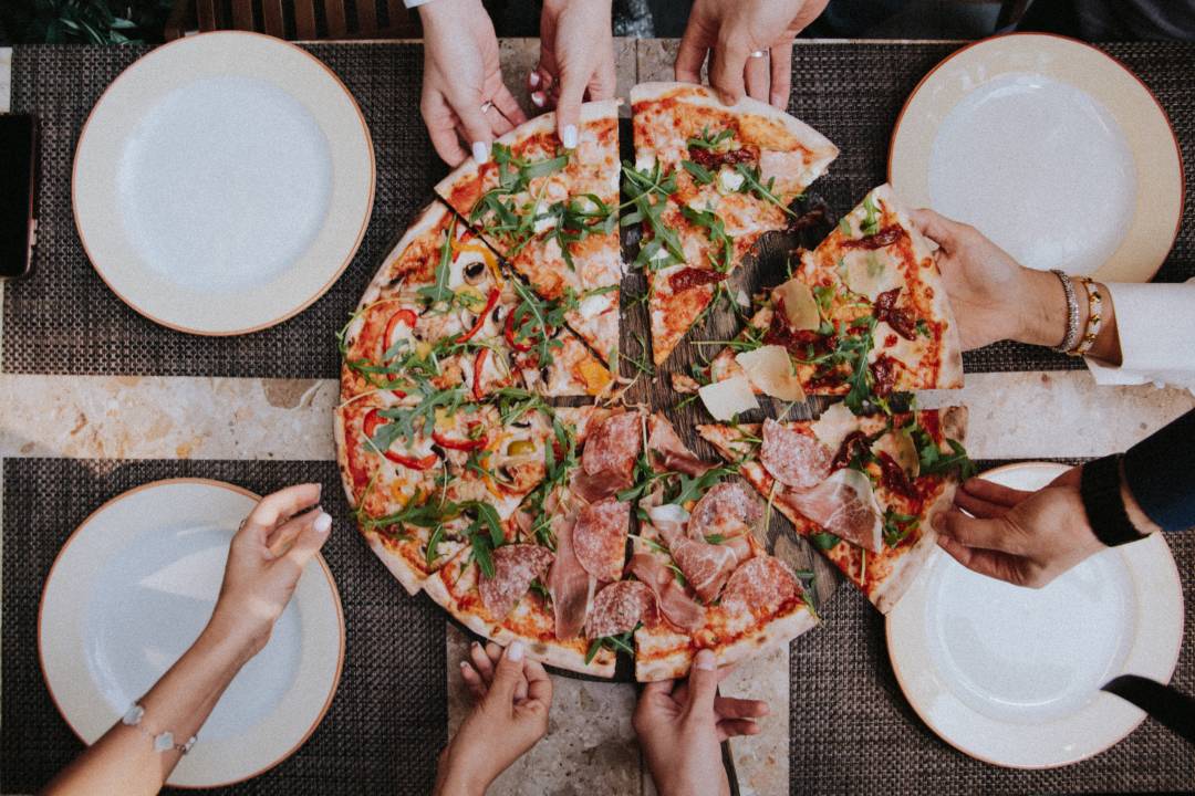 Aerial View Of People Taking Slices Of A Pizza