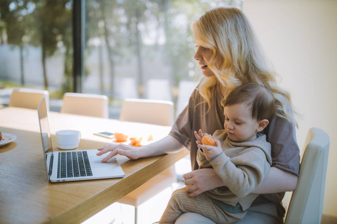 Mother Working Whilst Holding Her Child