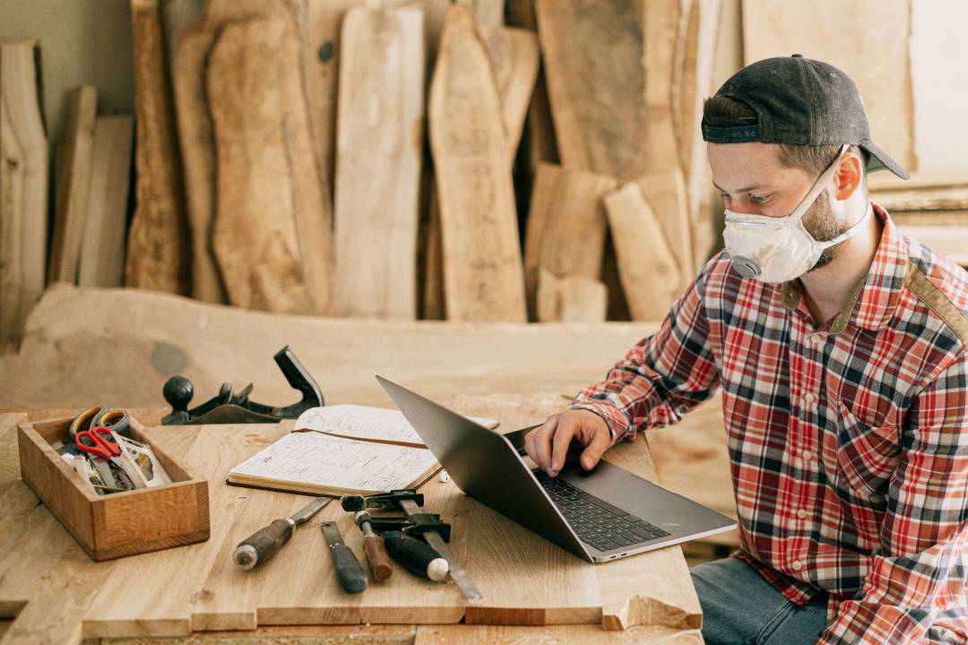 Man Using Computer In Carpentry Studio