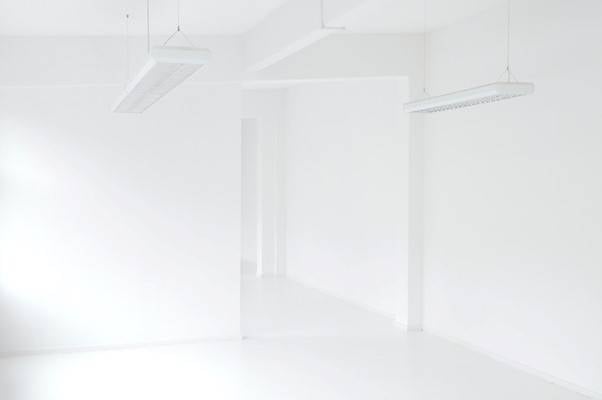 White room with fluorescent lights hanging from the ceiling
