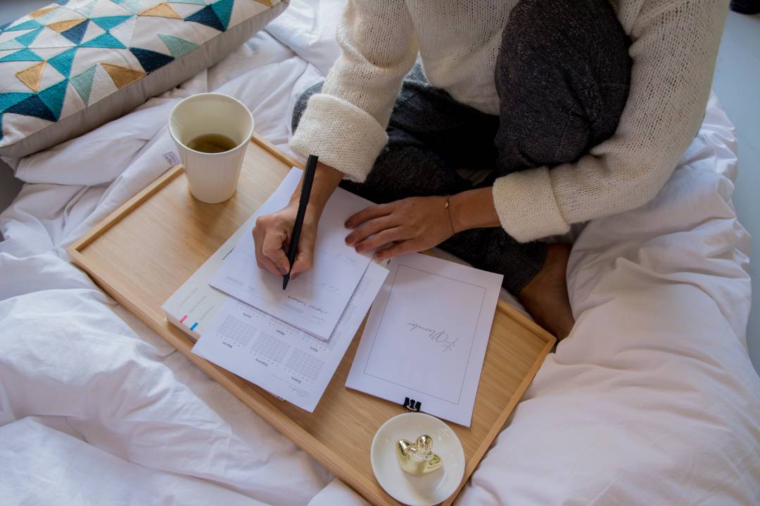 Woman Writing In Bed On A Wooden Board