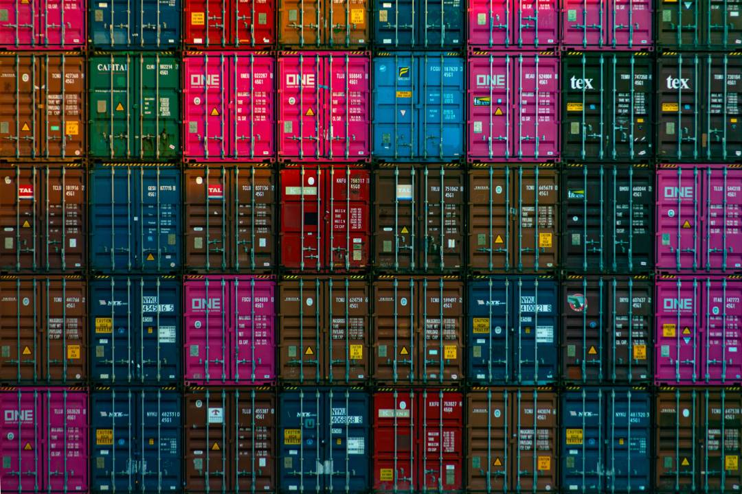 Shipping containers in different colours stacked on top of each other