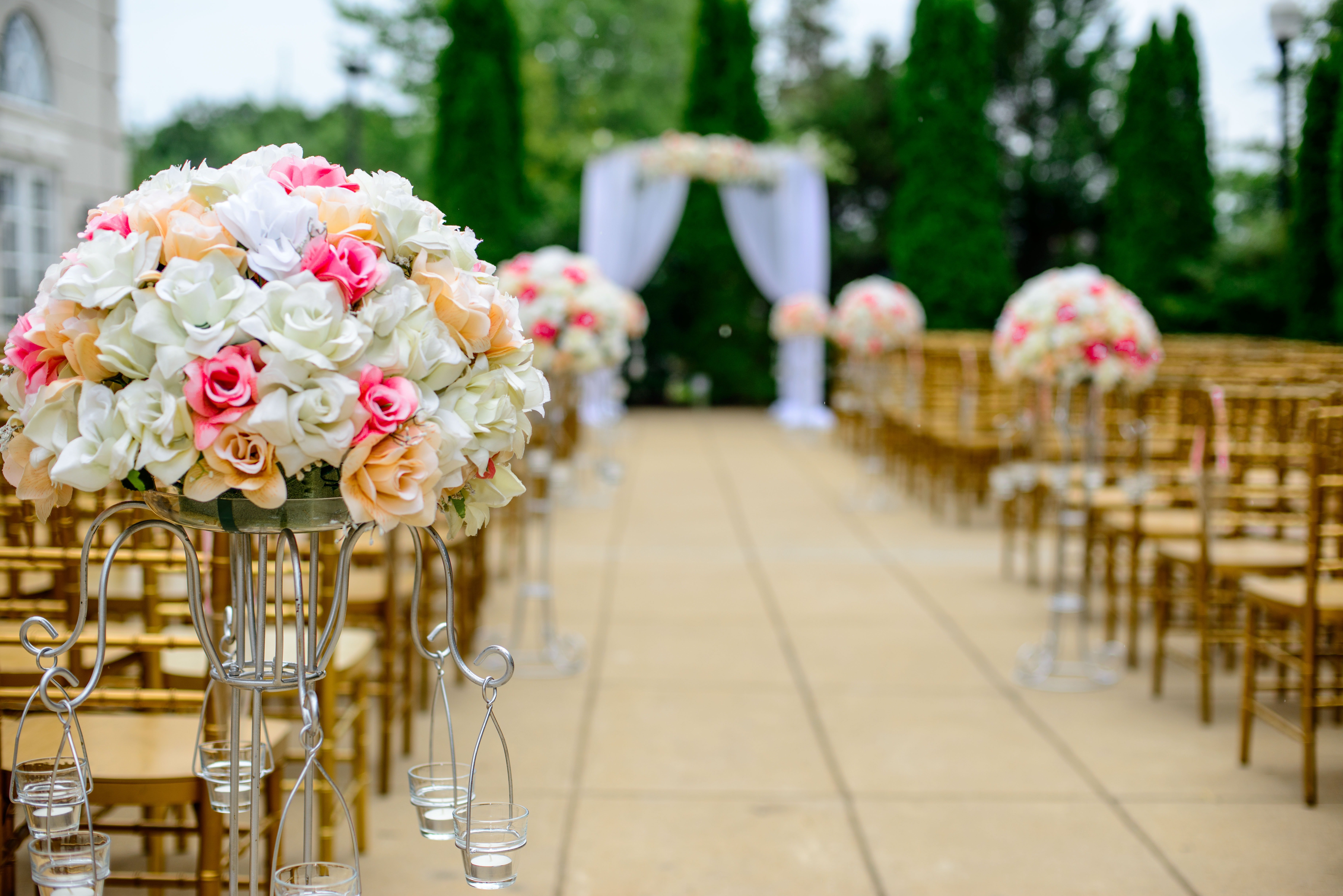 Rows of chair and flowers with a wedding arch in the background