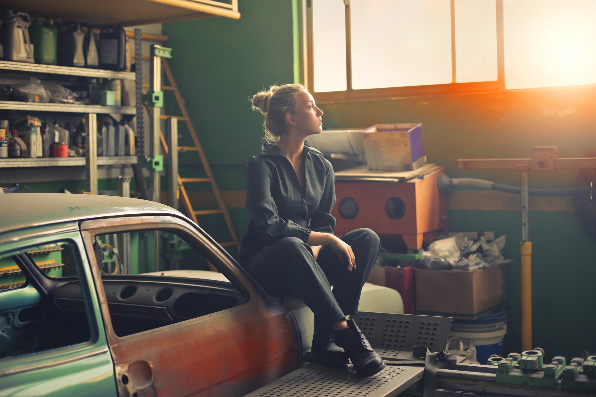 Woman Sitting On Bonnet Of A Car In A Garage