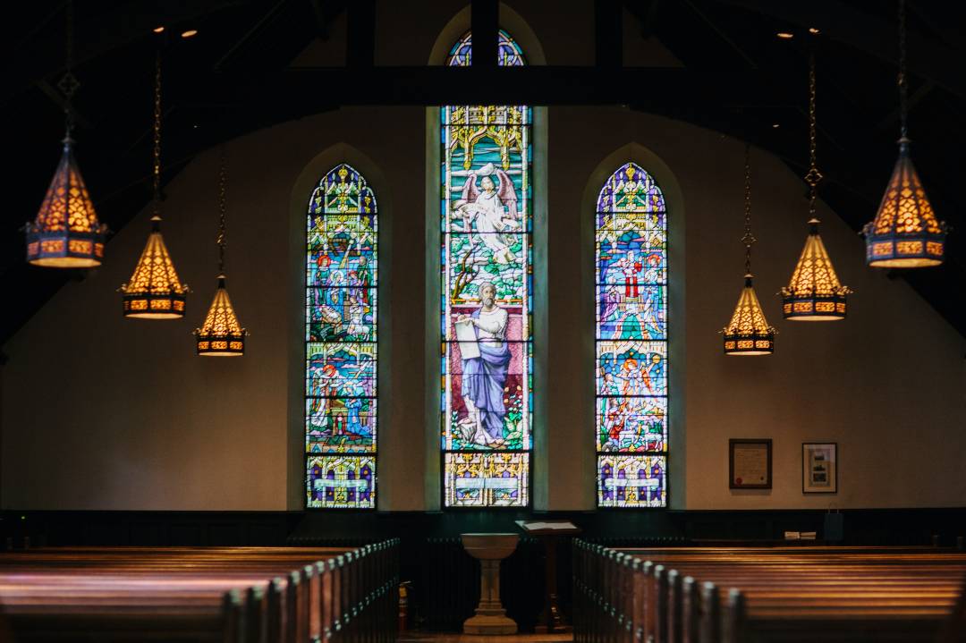 Large Stained Glass Window With Benches In Foreground